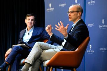 David Leonhardt (foreground) and JHU President Ron Daniels on stage