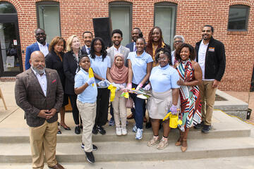 Community leaders and Henderson-Hopkins students and staff in a group photo with a ceremonial shovel