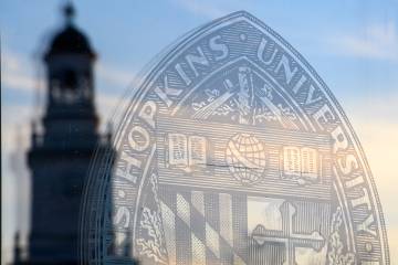 Gilman Hall reflection and university seal