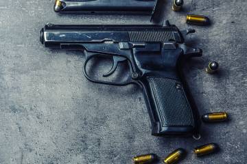A gun with bullets scattered around it